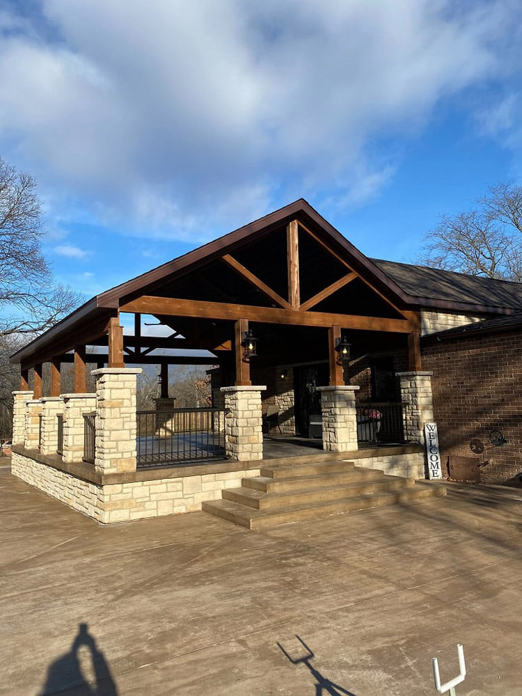 stone wrapped columns on a house porch along with a stone wrapped base